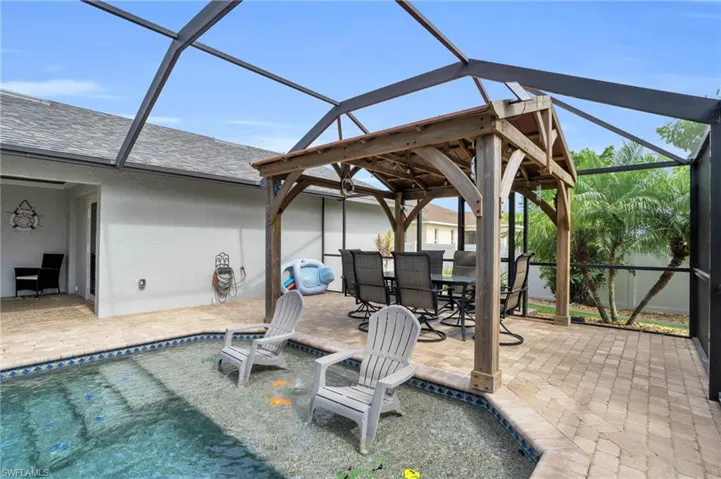 View of pool featuring a patio area and glass enclosure