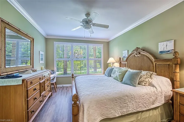 Bedroom with crown molding, hardwood / wood-style floors, and ceiling fan