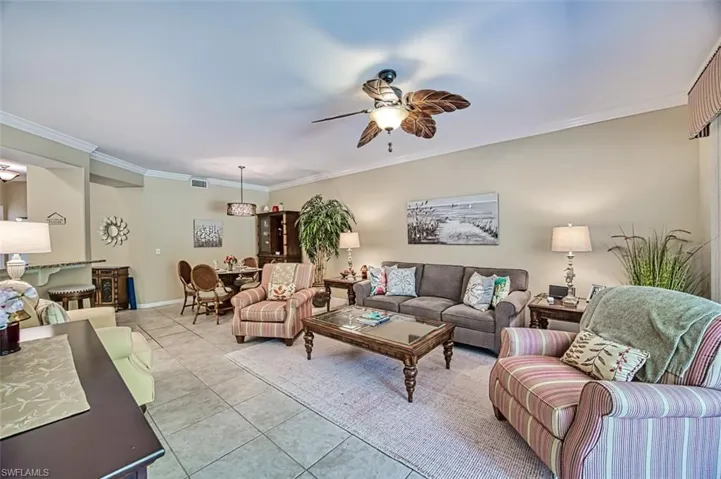 Tiled living room featuring crown molding and ceiling fan