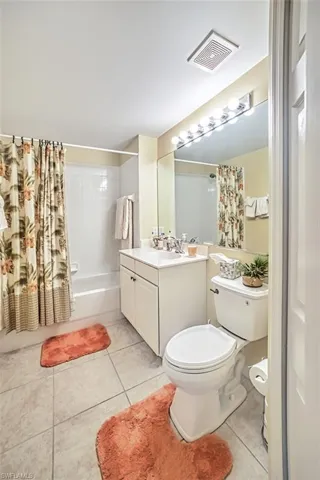 Full bathroom featuring vanity, tile patterned floors, shower / bath combo, and toilet