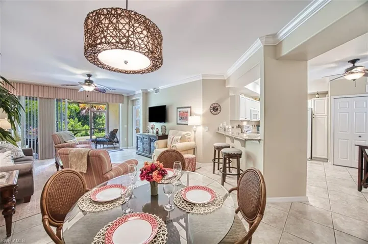 Tiled dining room with ornamental molding and ceiling fan