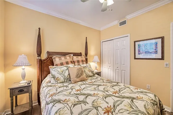 Bedroom featuring dark hardwood / wood-style flooring, crown molding, a closet, and ceiling fan