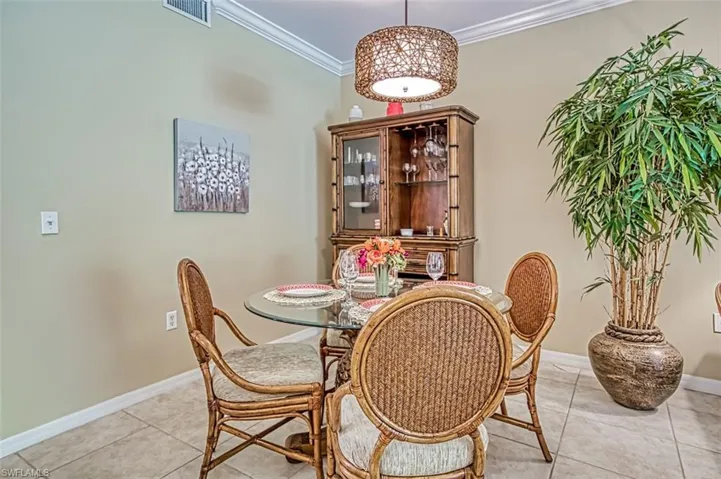 Tiled dining space featuring crown molding