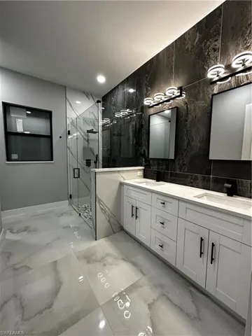 Master bathroom with custom wall tiles, glass shower and custom dual sinks