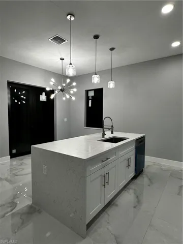 Dining area and kitchen island with custom light fixtures