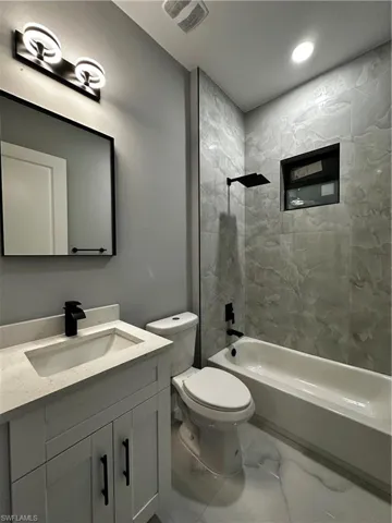 Bathroom with custom cabinet sink, mirror and light fixture