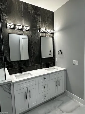 Dual sinks with custom cabinetry, mirrors and light fixtures