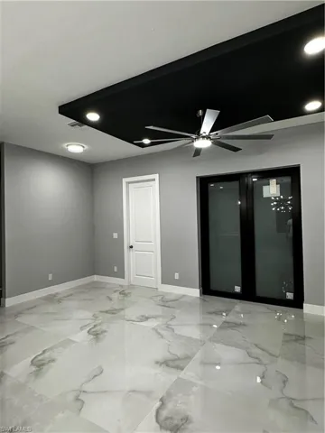 Entrance view with custom tray ceiling detail and living area with remote controlled ceiling fans