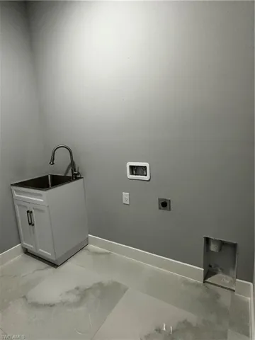 In home laundry with custom cabinet sink and washer / dryer hookup