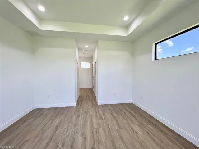Spare room featuring a tray ceiling and hardwood / wood-style flooring