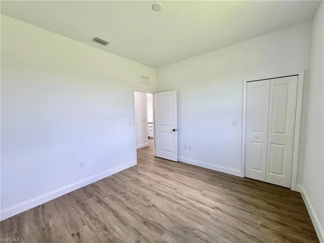 Unfurnished bedroom with a closet and hardwood / wood-style floors