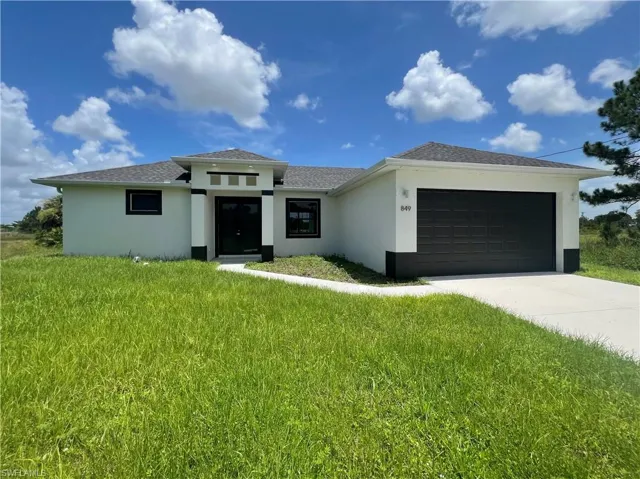 Prairie-style home with a garage and a front yard