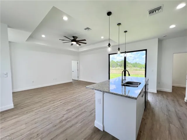 Kitchen featuring ceiling fan, sink, and light hardwood / wood-style flooring