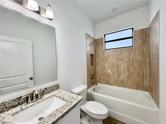 Full bathroom with vanity, toilet, and tiled shower / bath