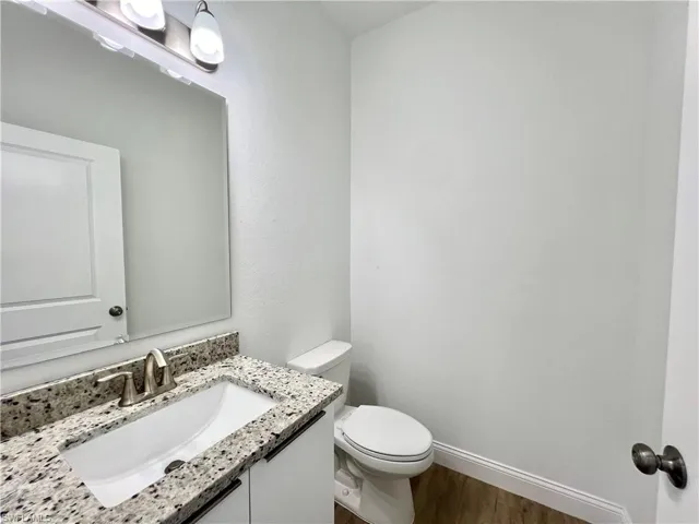 Bathroom with wood-type flooring, toilet, and vanity