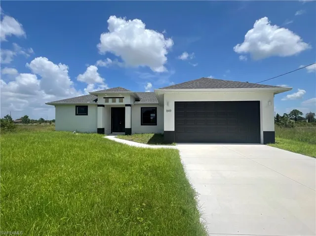 View of front of home featuring a garage and a front lawn