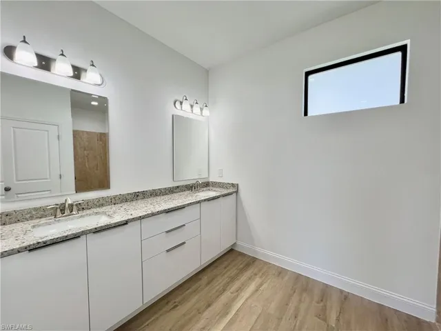 Bathroom featuring wood-type flooring and dual bowl vanity