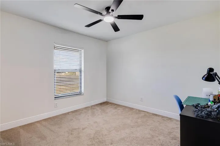 Unfurnished office with light colored carpet and a ceiling fan
