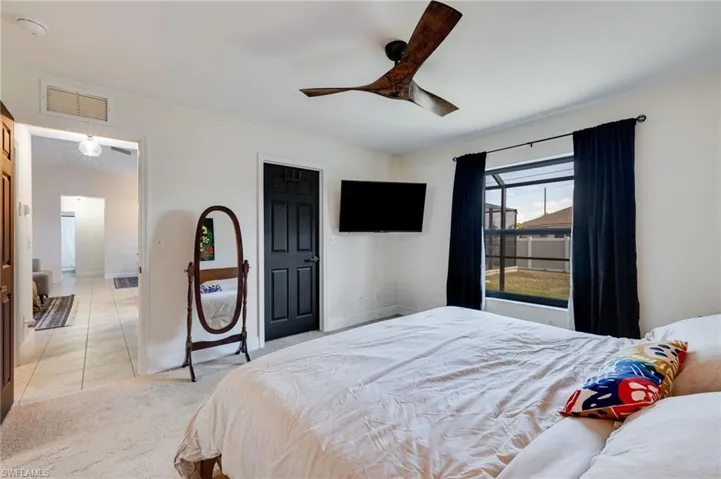 Bedroom featuring light carpet and a ceiling fan
