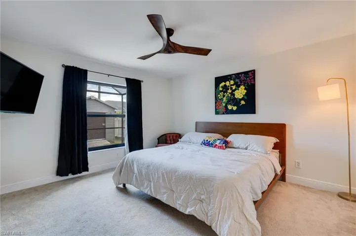 Carpeted bedroom featuring baseboards and ceiling fan