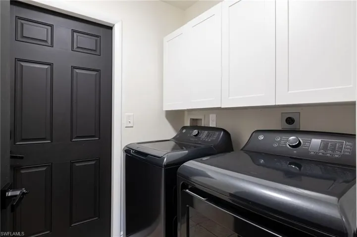 Laundry area featuring washer and dryer and cabinet space