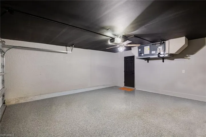 Garage with baseboards and a garage door opener