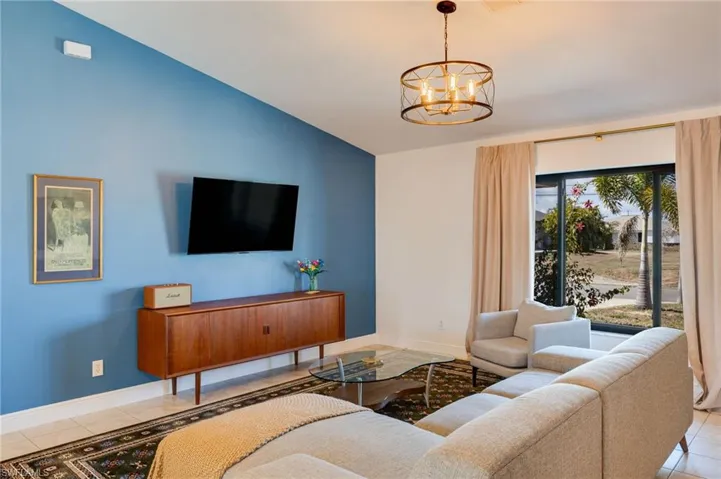 Tiled living room featuring a chandelier and lofted ceiling