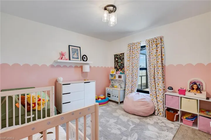 Bedroom with light carpet and a nursery area