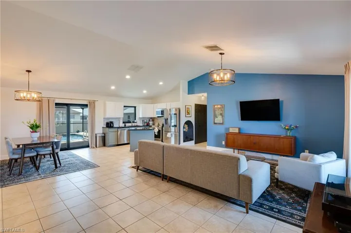 Living area featuring hanging lights, light tile patterned flooring, and a high ceiling