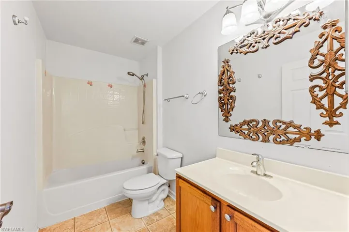 Full bath with vanity, shower / tub combination, and tile patterned flooring