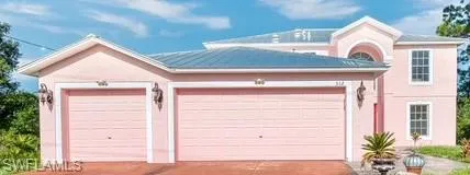 View of front of home with an attached garage, driveway, and stucco siding