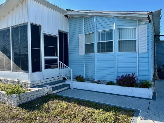 View of side of property with a sunroom