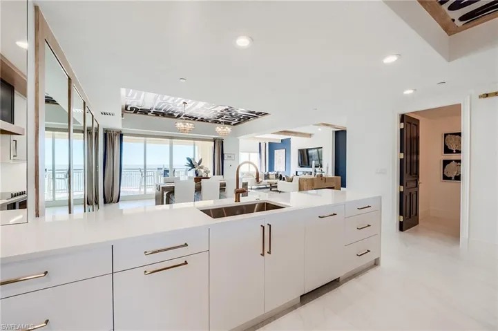 Kitchen with a sink, open floor plan, light countertops, white cabinetry, and recessed lighting