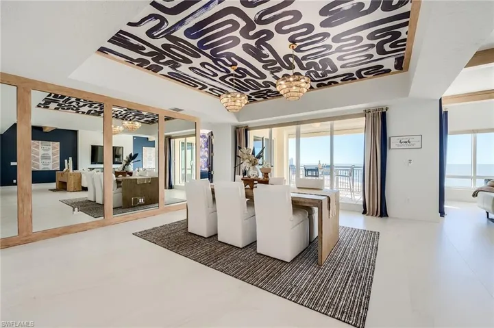 Dining space with plenty of natural light, a water view, and a raised ceiling