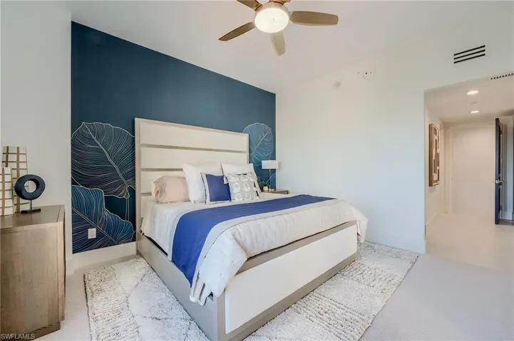 Carpeted bedroom with a ceiling fan