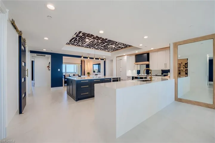 Kitchen with a center island, light countertops, recessed lighting, white cabinets, and a barn door