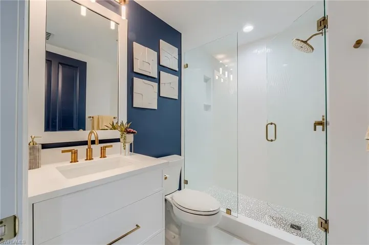 Full bathroom with a stall shower, toilet, and vanity