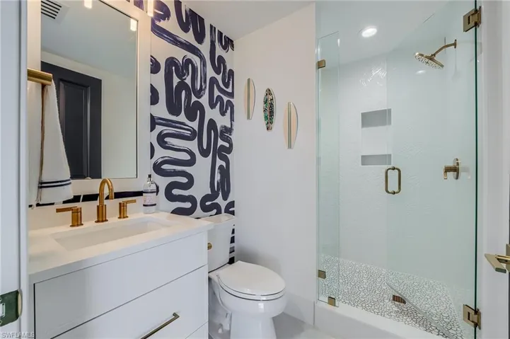 Full bathroom featuring toilet, a shower stall, vanity, and recessed lighting