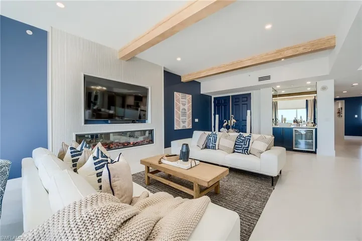 Living area with bar, beamed ceiling, wine cooler, and recessed lighting