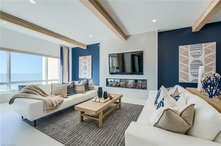 Living area featuring beamed ceiling and recessed lighting