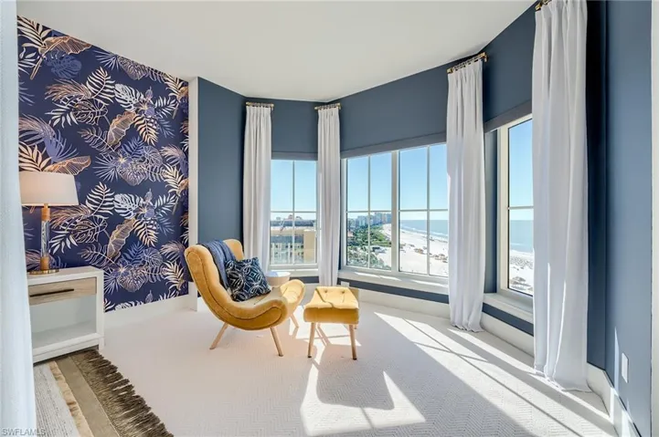 Living area with carpet flooring, wallpapered walls, and an accent wall