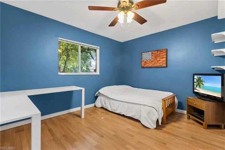Bedroom with light hardwood / wood-style floors and ceiling fan
