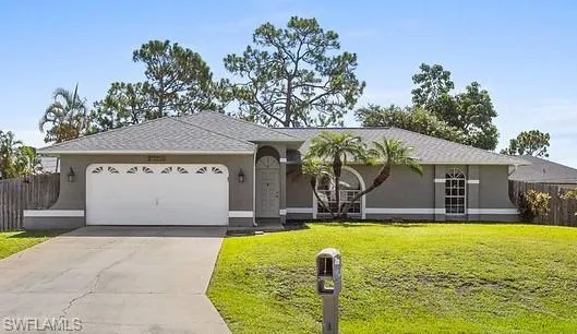 Ranch-style home with a garage and a front lawn