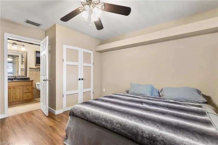 Bedroom featuring light hardwood / wood-style floors, ensuite bathroom, sink, and ceiling fan
