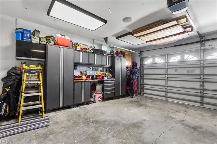 Garage featuring a garage door opener and a workshop area