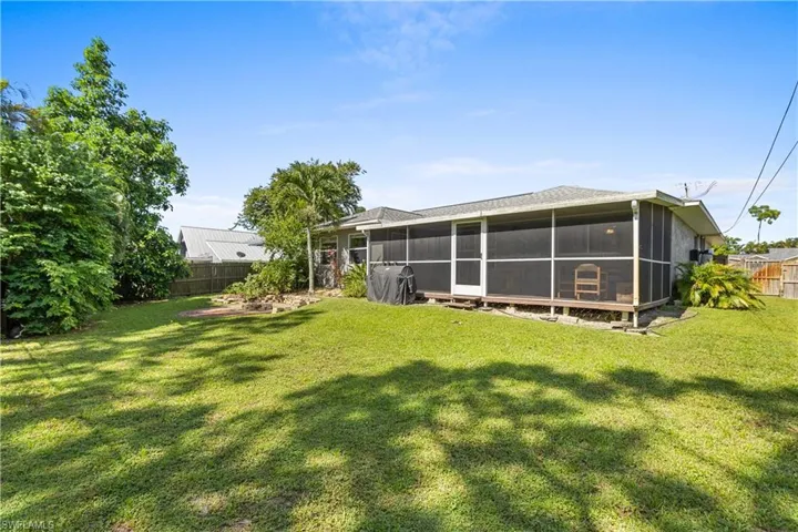 Rear view of property with a sunroom and a yard