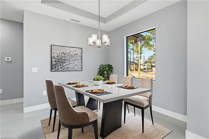 Dining area with a tray ceiling and hanging lights