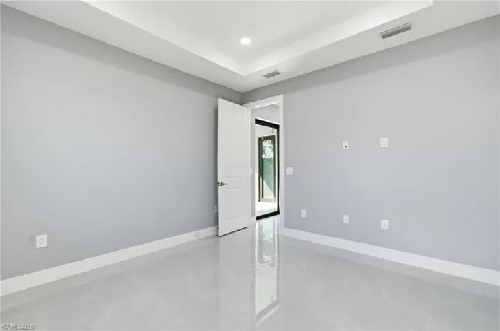 Unfurnished room with a raised ceiling and recessed lighting