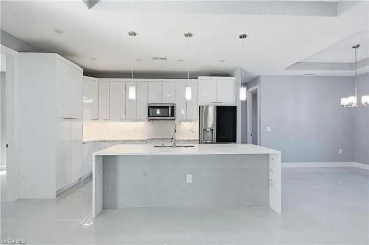 Kitchen featuring white cabinetry, modern cabinets, and light stone counters