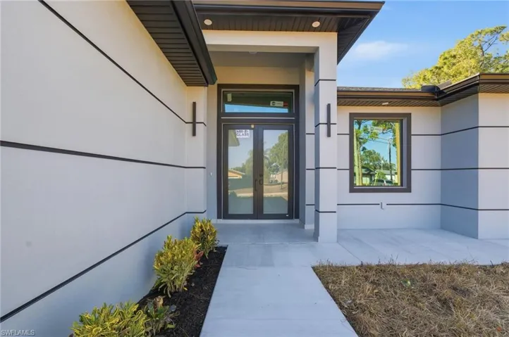Doorway to property featuring french doors and stucco siding